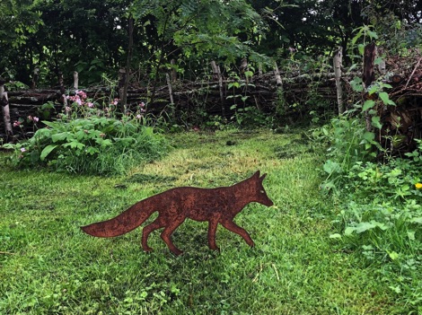 Walking fox decoration on green grass